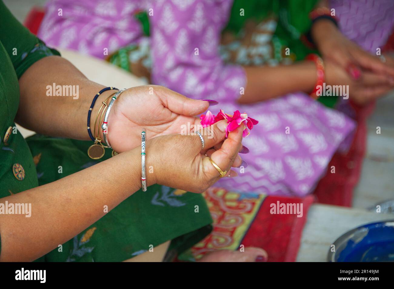 Mano della donna che tiene petali di rose mentre prega in attesa dell'aiuto di Dio Foto Stock