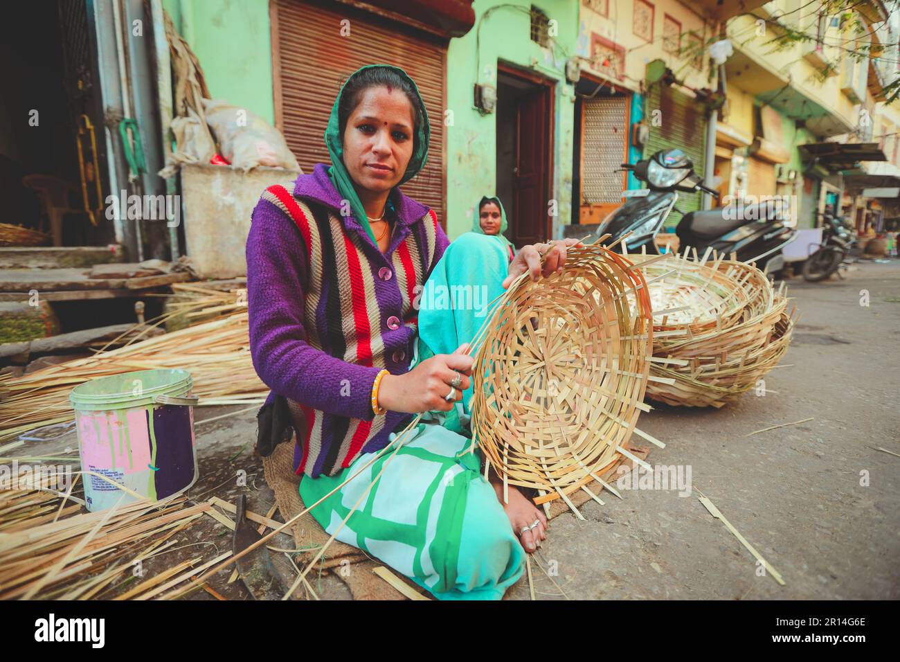 Jaisalmer, India - 19 gennaio 2020 : Soft focus on Indian woman weaves a bambù basket . Bambù basketry fatto vaso. Foto Stock