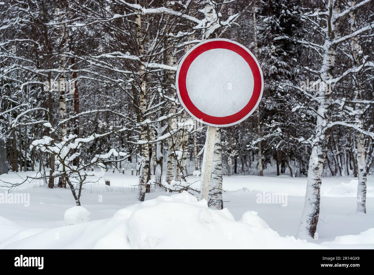 Cartello stradale "No motor vehicles" in una grande nevicata sullo sfondo di una foresta invernale. Foto Stock