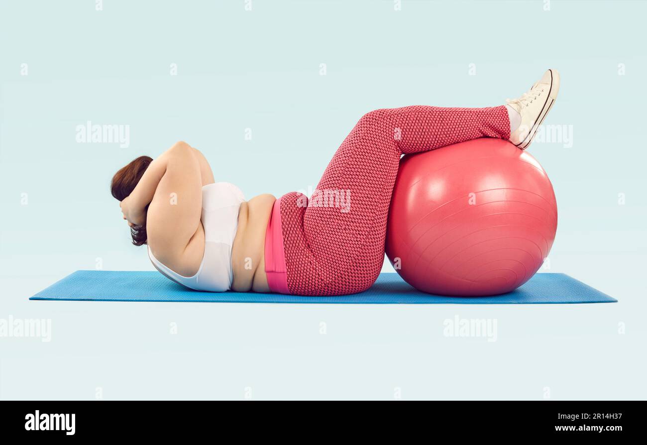 Donna sovrappeso sdraiata sul tappeto sportivo e facendo esercizi di scricchiolatura con la palla svizzera Foto Stock