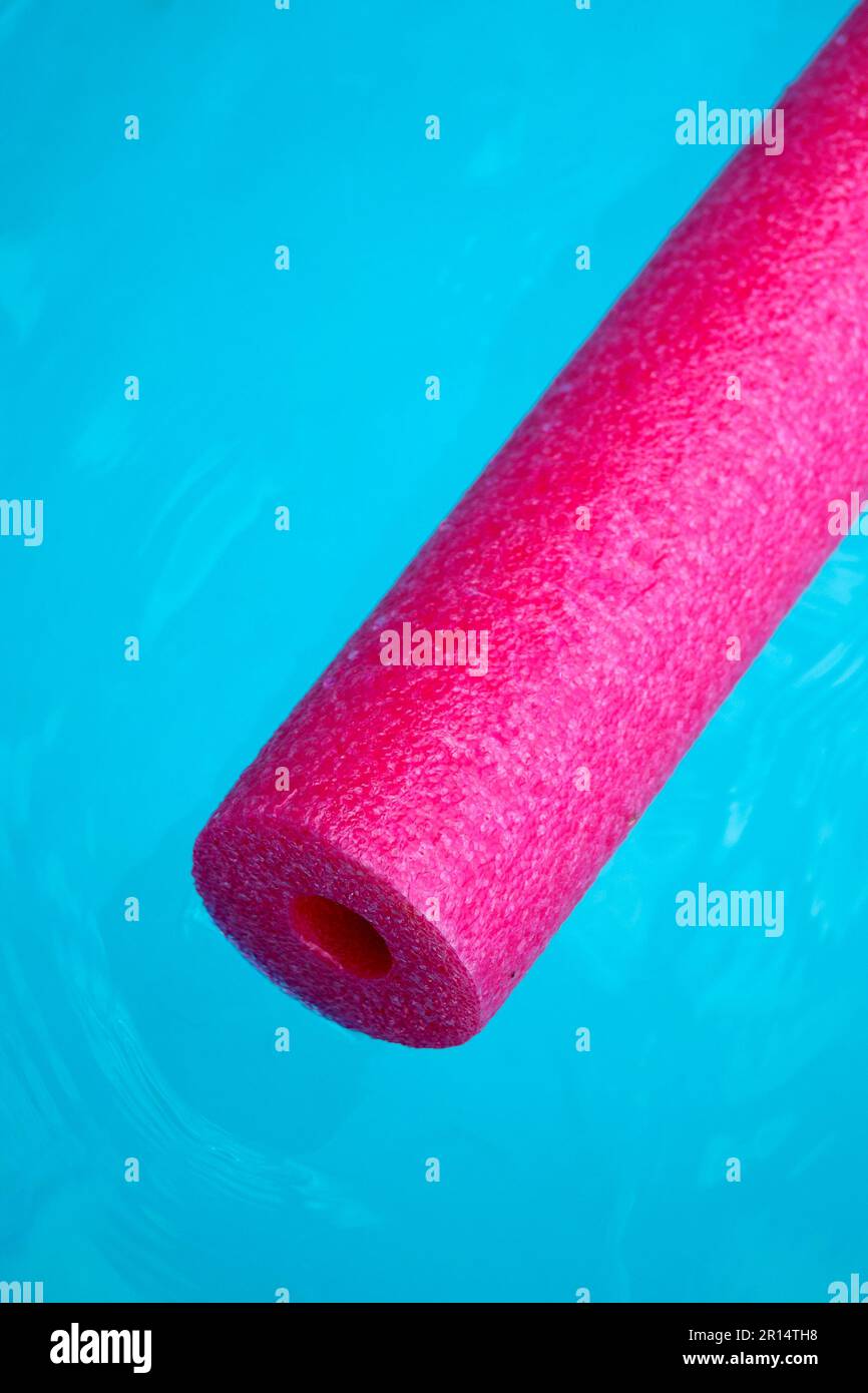 noodle rosa della piscina che galleggia sull'acqua blu Foto Stock