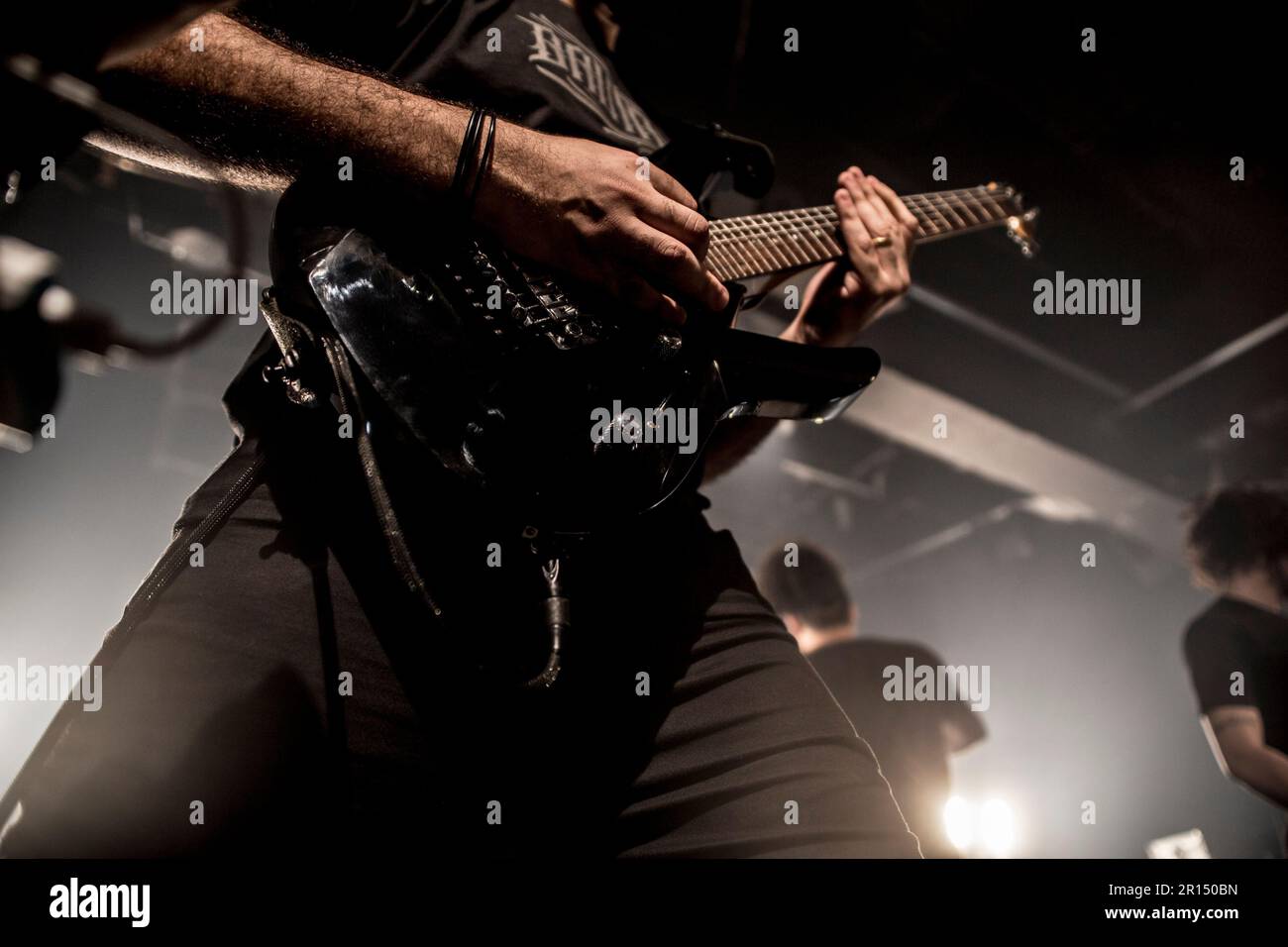 Un'inquadratura a basso angolo di un musicista che suona una chitarra acustica su un palco in un concerto Foto Stock