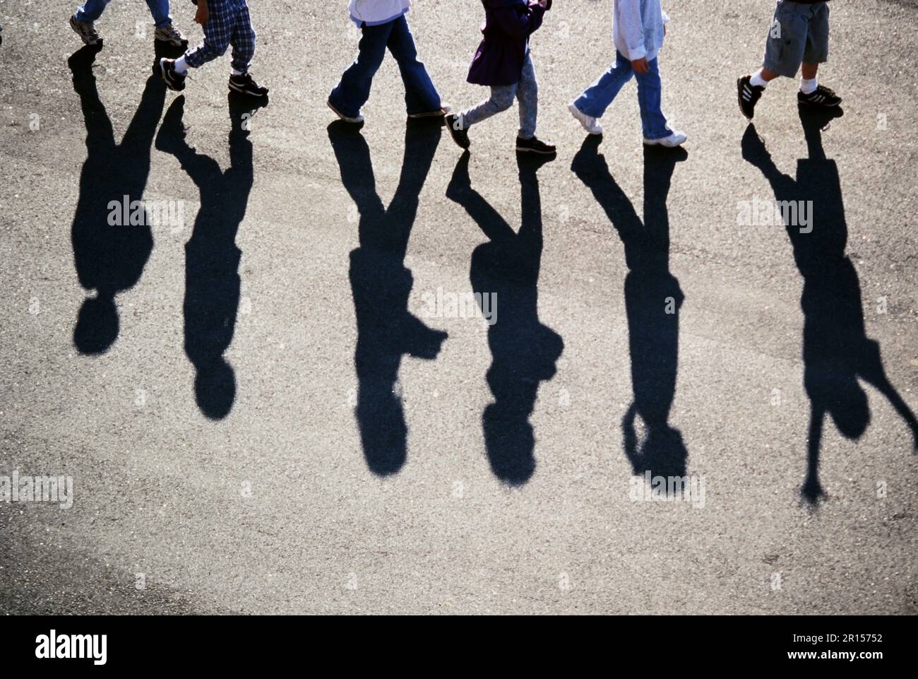 Una linea di ombre telefono da un gruppo di bambini che camminano attraverso un parco giochi hi hi Foto Stock
