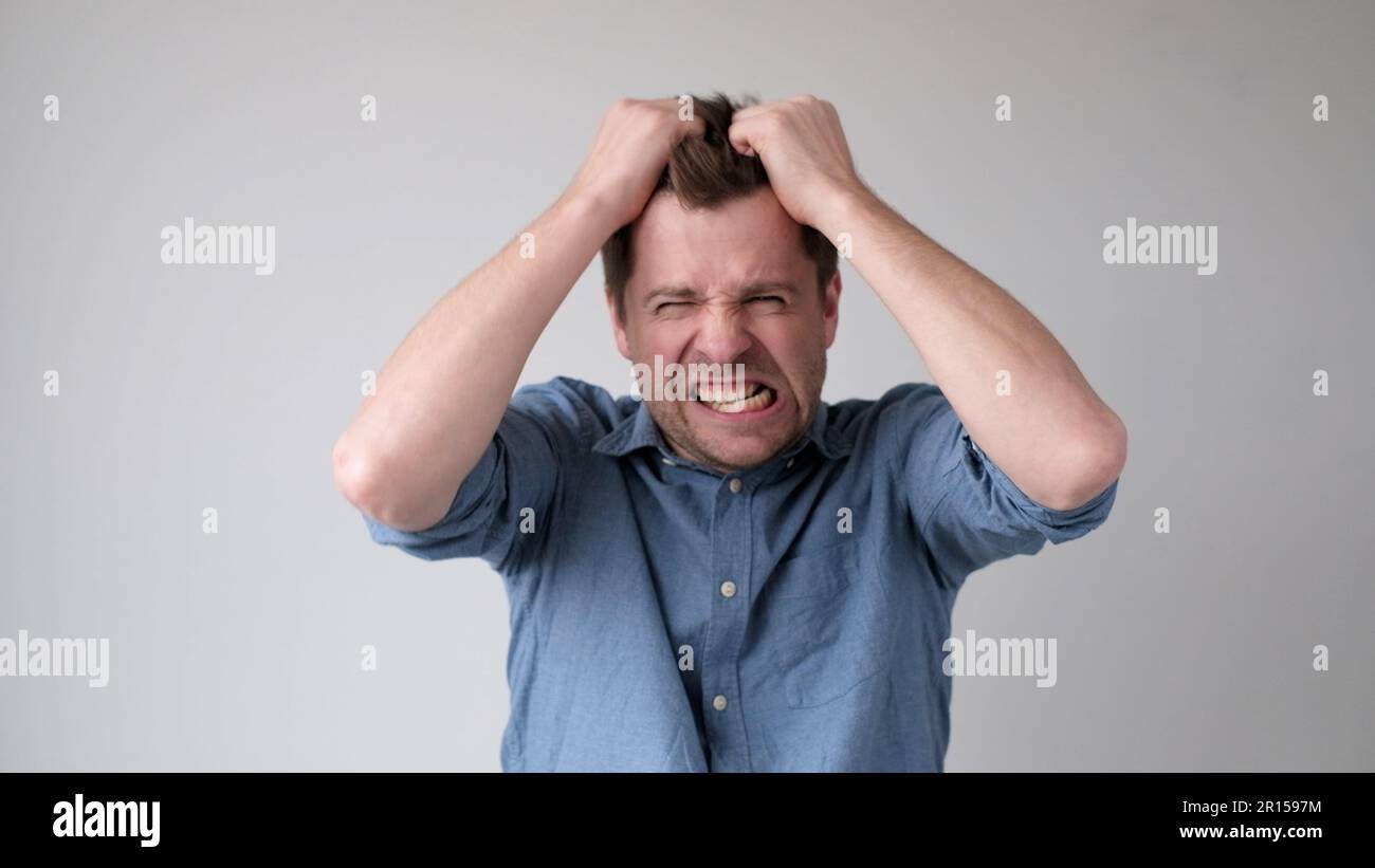 Il giovane europeo si sta lacerando i capelli nella disperazione dopo aver sentito cattive notizie. Foto Stock