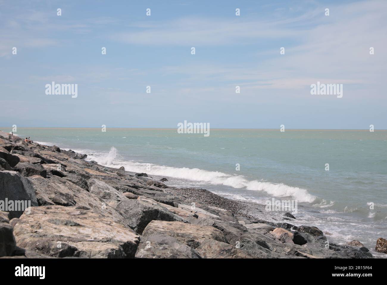 Pittoresca vista delle onde schiumose che colpiscono la costa rocciosa Foto Stock