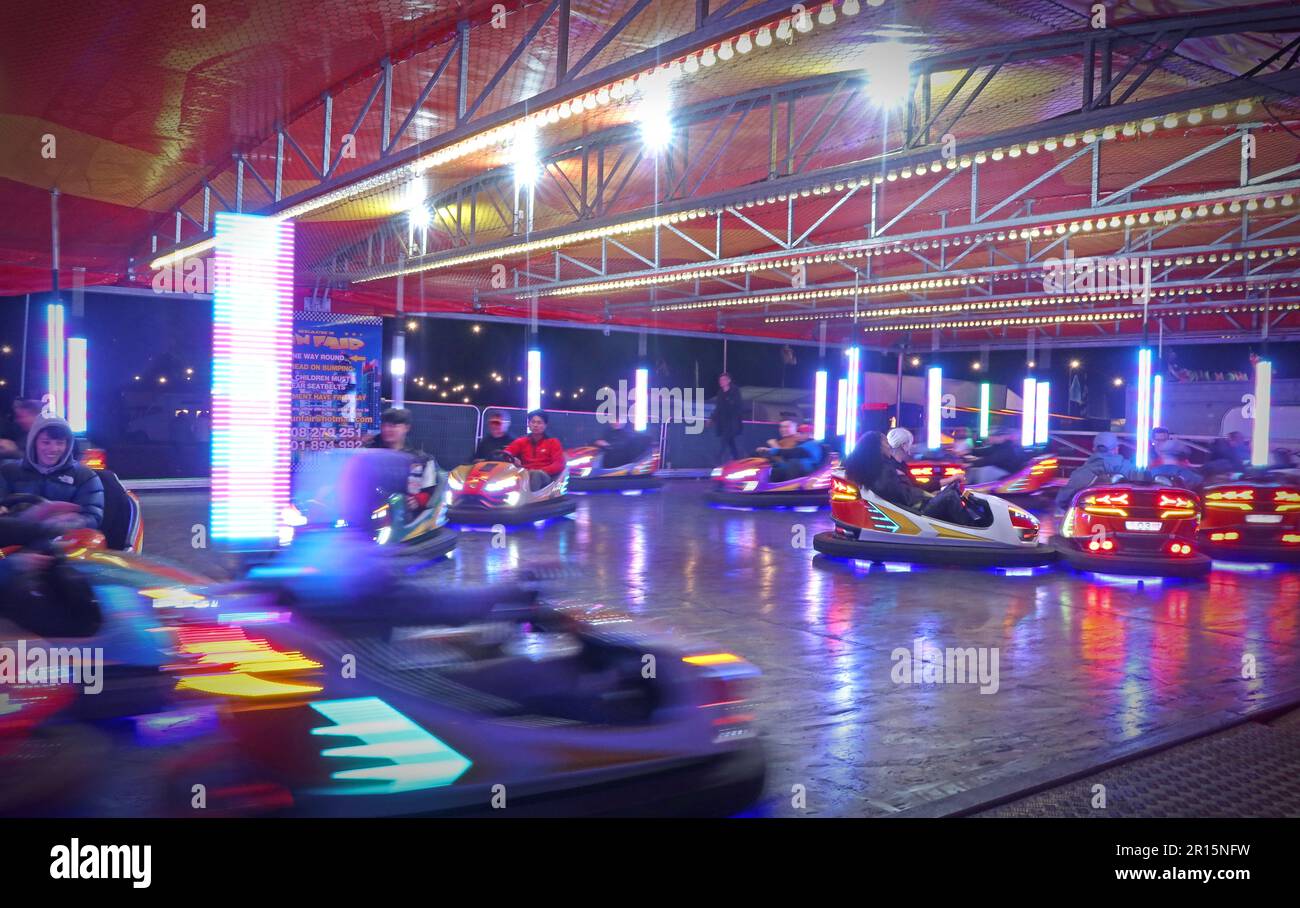 Auto paraurti in movimento ad un luna Park, divertimenti in Inghilterra, Regno Unito al crepuscolo Foto Stock