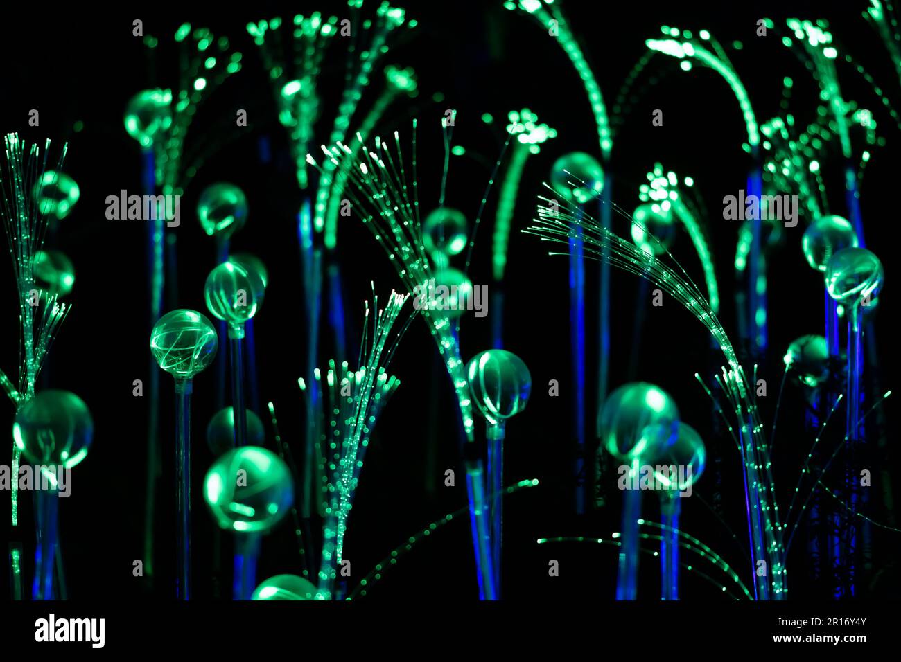 Filamenti o filamenti in fibra ottica verde e blu che creano un fantastico sfondo astratto magico, intelligenza artificiale ai o concetto di realtà virtuale Foto Stock