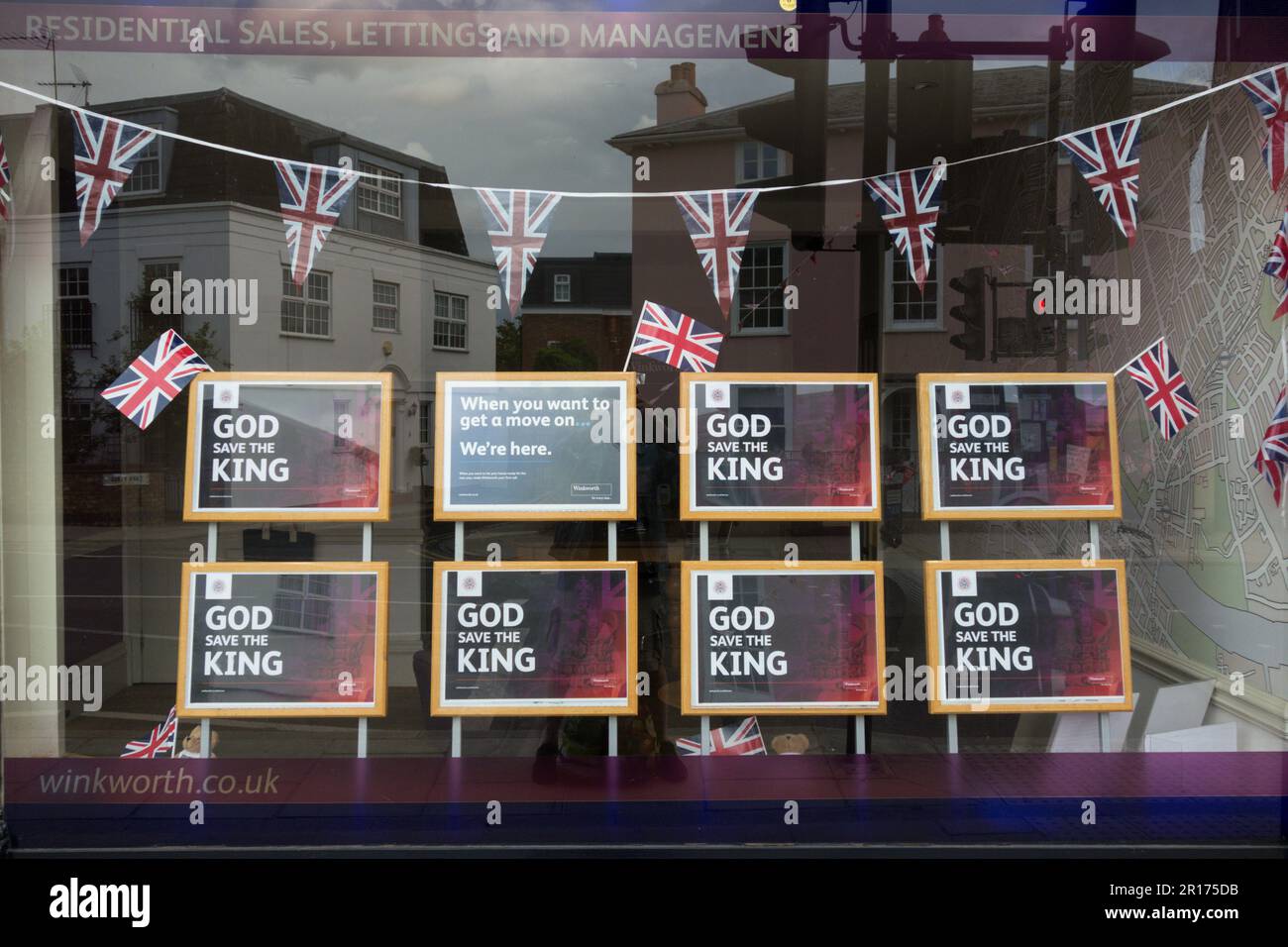 Il cartello di God Save the King nella vetrina di un'agenzia immobiliare che mostra il coniglietto delle celebrazioni per l'incoronazione reale e Union Jacks, Londra, Inghilterra, Regno Unito Foto Stock