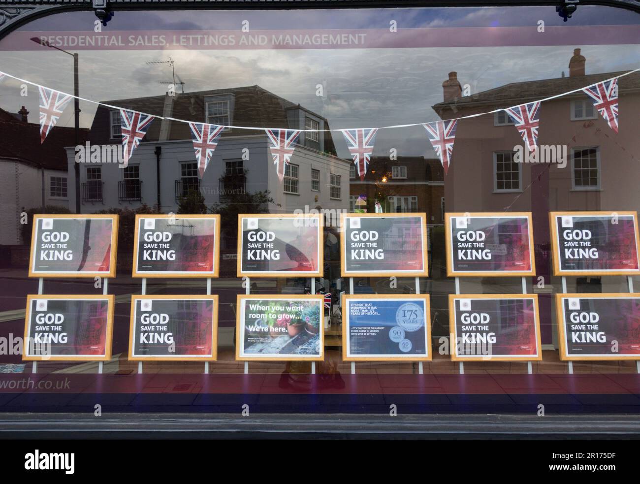 Il cartello di God Save the King nella vetrina di un'agenzia immobiliare che mostra il coniglietto delle celebrazioni per l'incoronazione reale e Union Jacks, Londra, Inghilterra, Regno Unito Foto Stock