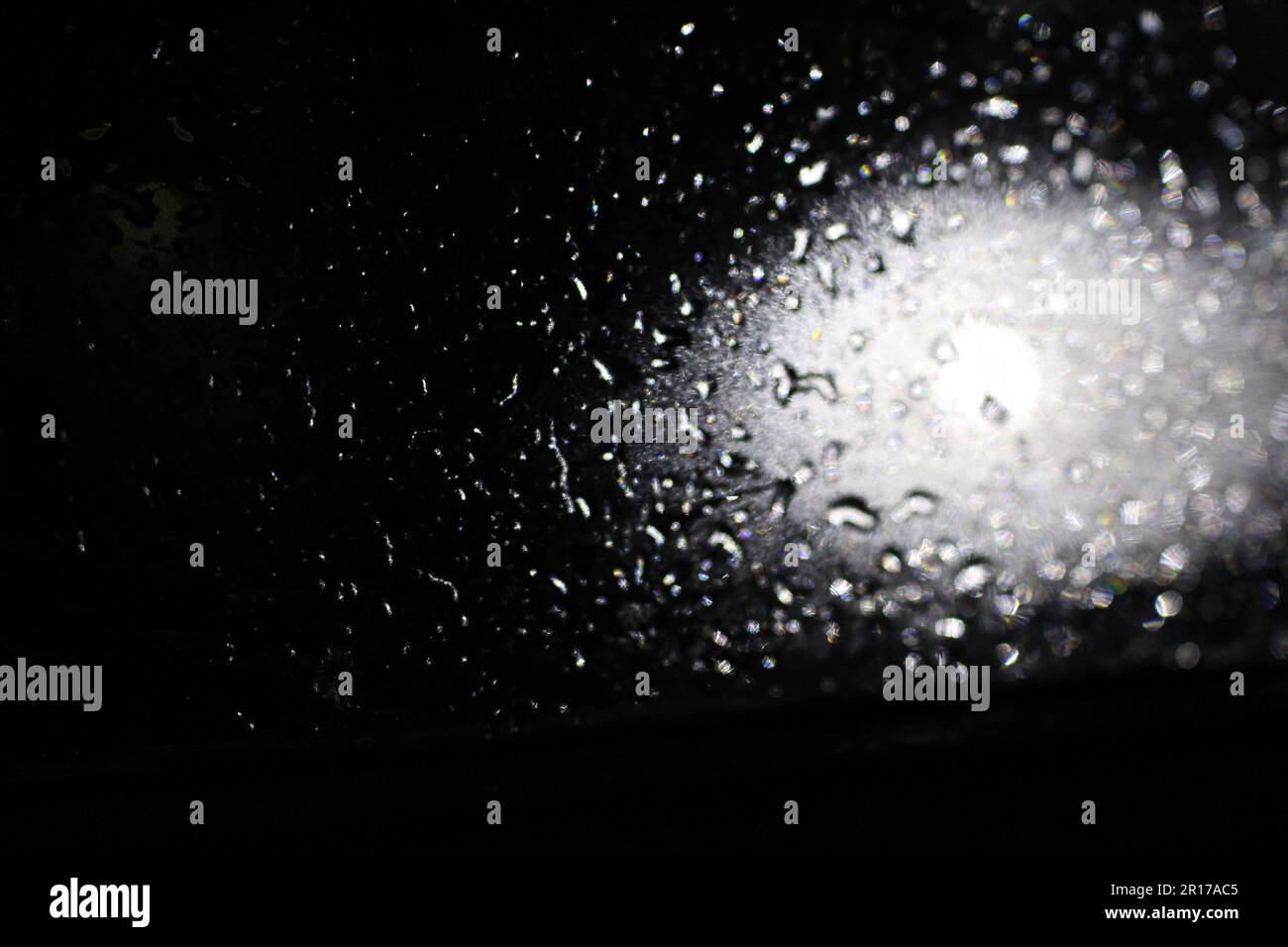 Effetto flare della lente con gocce bagnate su sfondo nero. Sovrapposizione, effetti della luce solare, perdite di luce Foto Stock