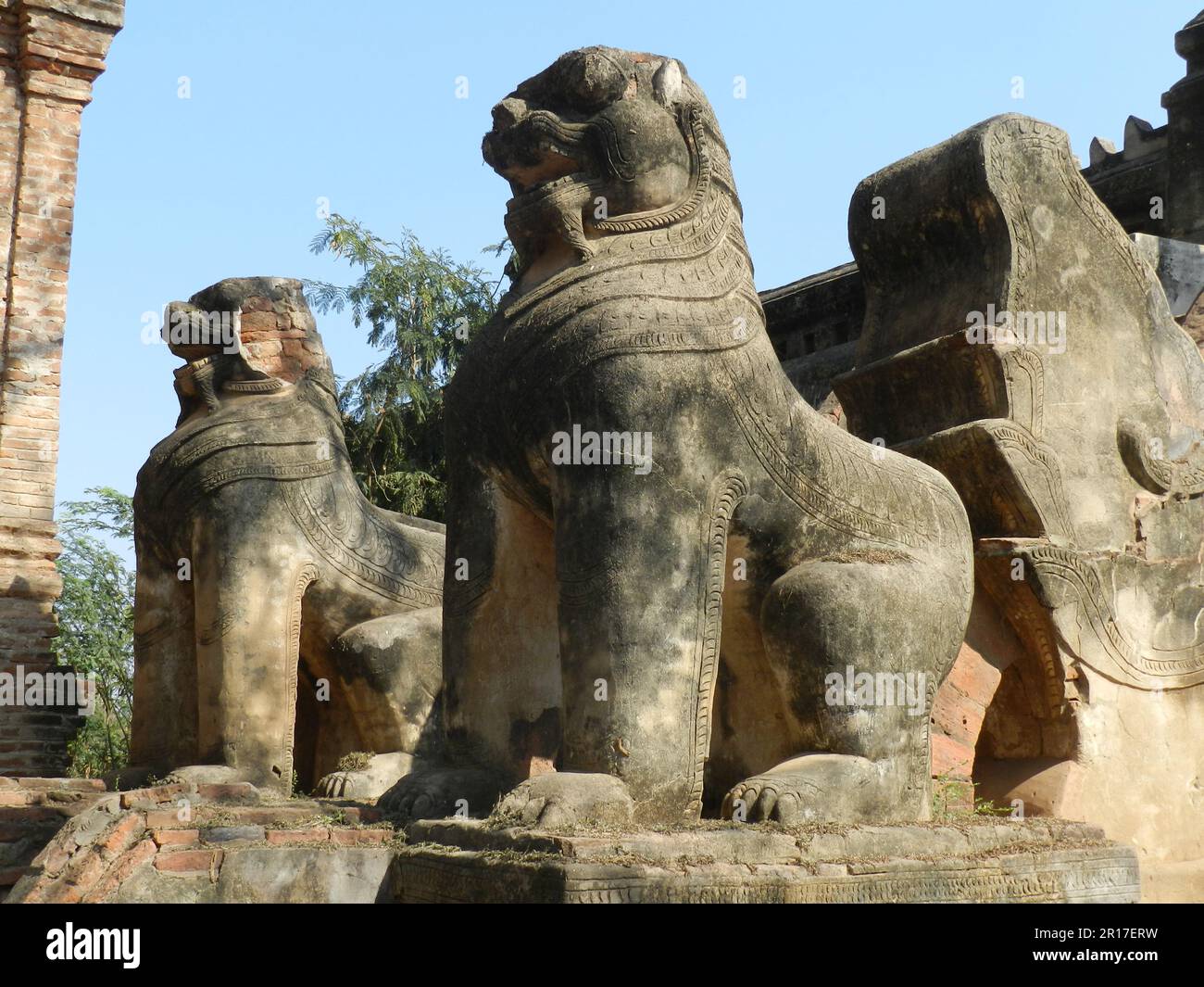 Myanmar, Bagan: Un paio di cinte (mezzo leone, mezzo drago bestie mitiche) che custodiscono la scala di Mimalaung Kyaung (monastero), costruito nel 1174 Foto Stock