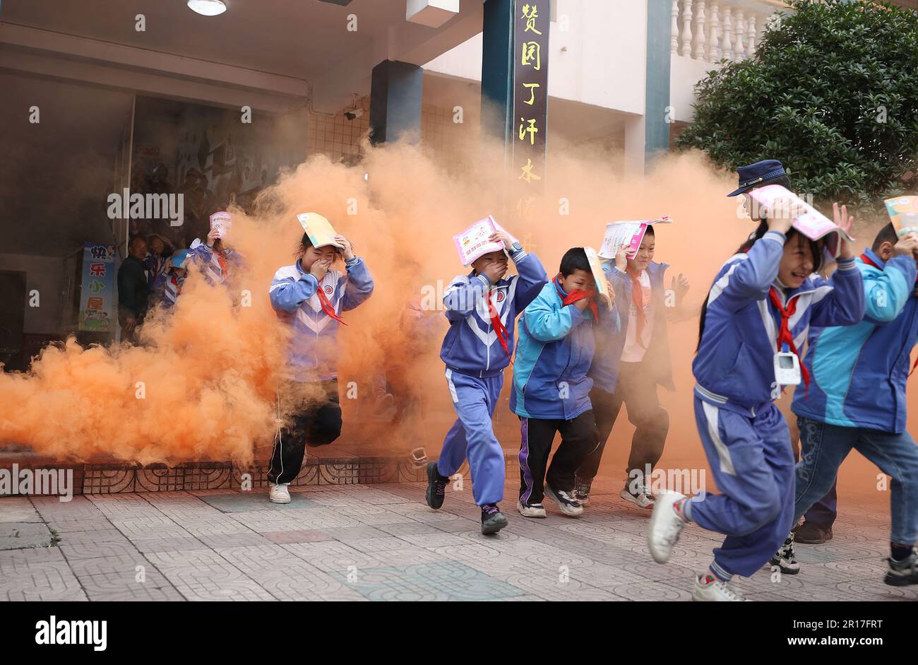 QIANDONGNAN, CINA - 12 MAGGIO 2023 - gli studenti della scuola primaria partecipano ad un'esercitazione di evacuazione sotto il comando dei vigili del fuoco a Qiandongnan Miao An Foto Stock