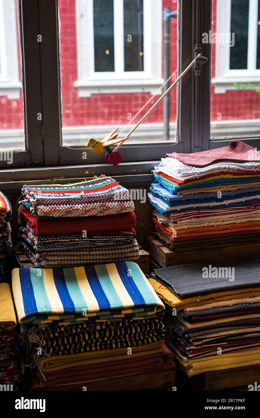 Pila di tappeti colorati accanto alla finestra. Foto Stock