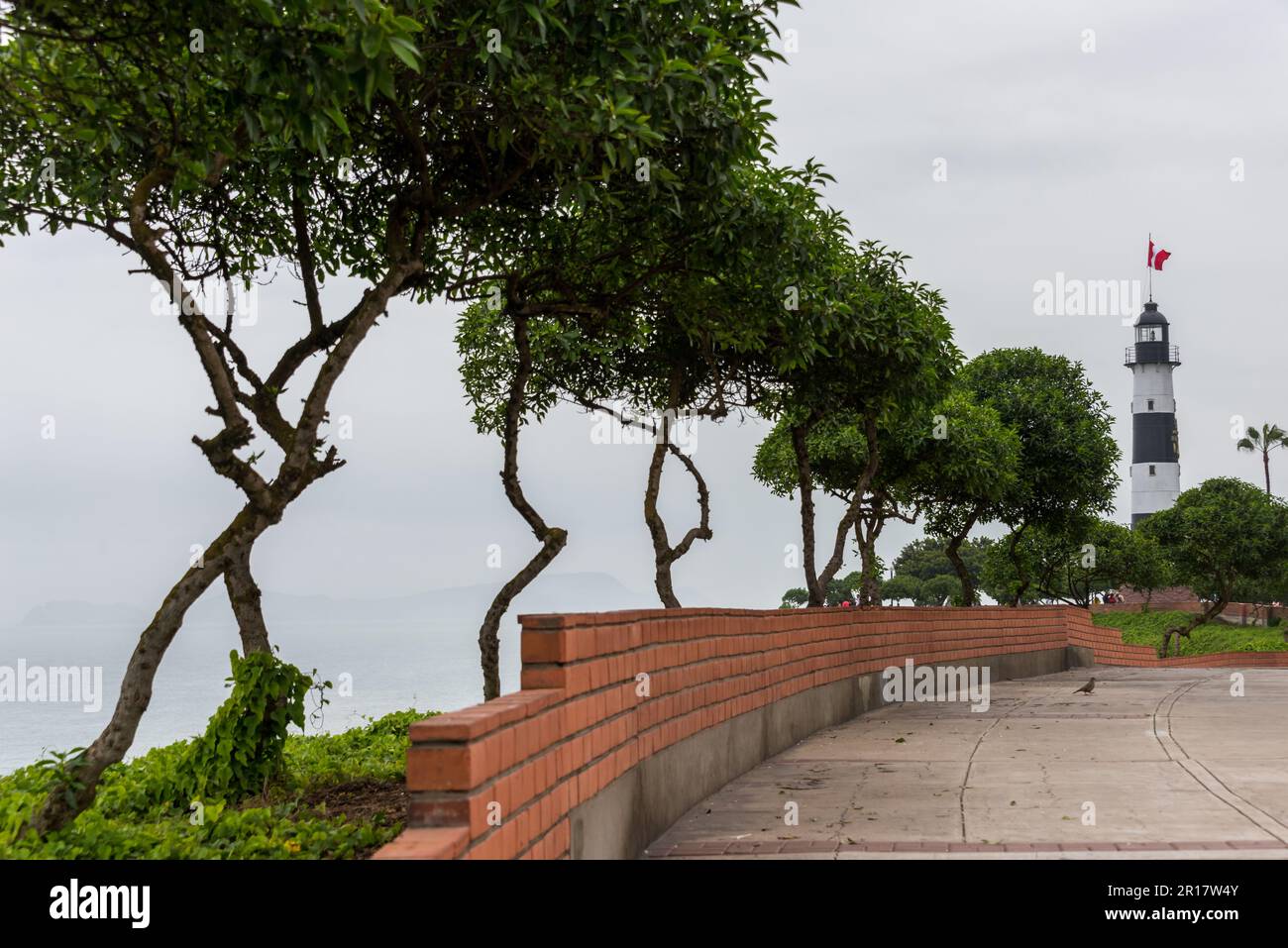 Linea di alberi e il faro di Miraflores alla fine Foto Stock