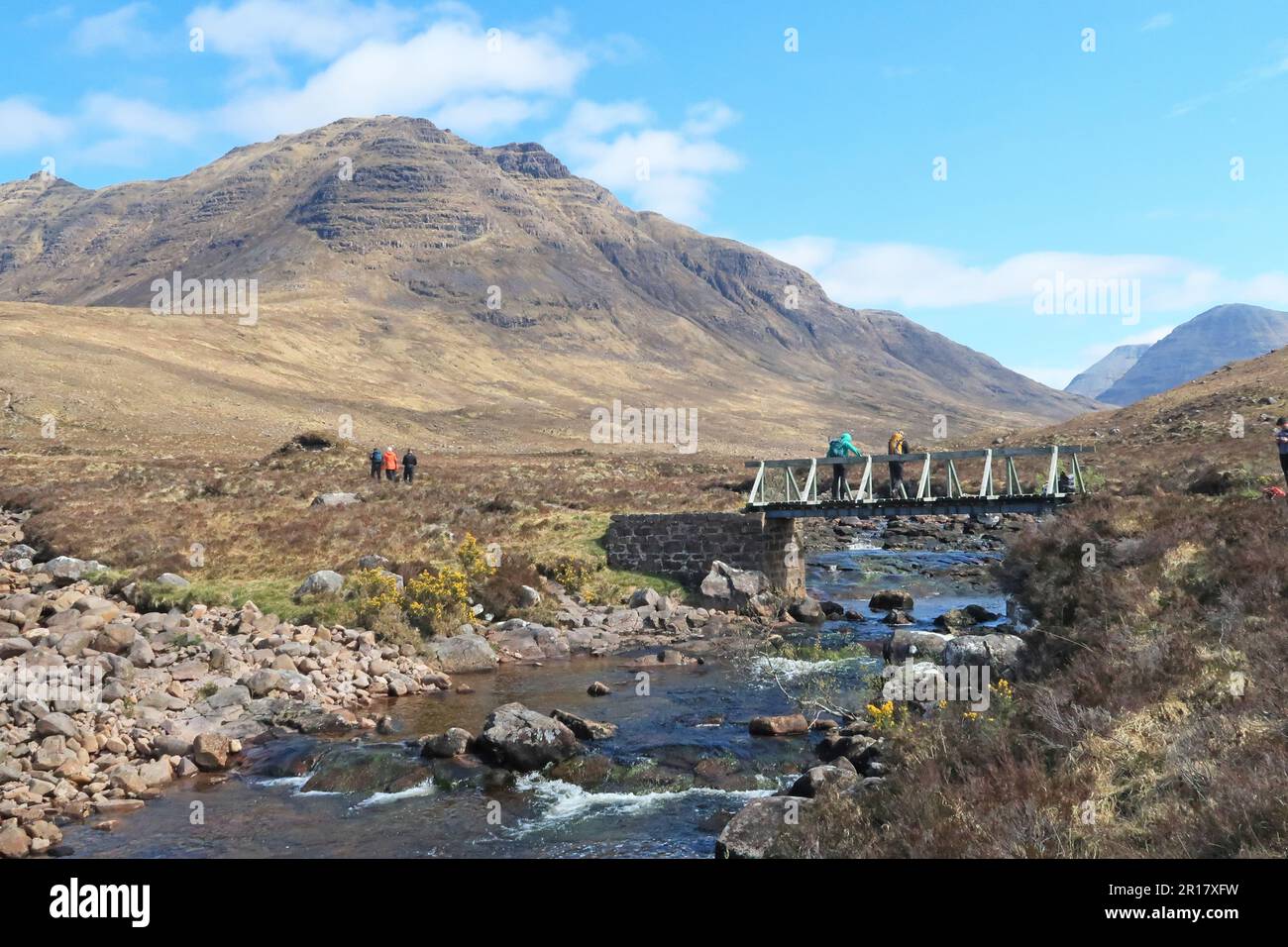 Highlands scozzesi: Camminatori nella valle di Coire MhicNobaill, vicino a Torridon. Mostra il suggestivo picco di Beinn Dearg sullo sfondo. Foto Stock