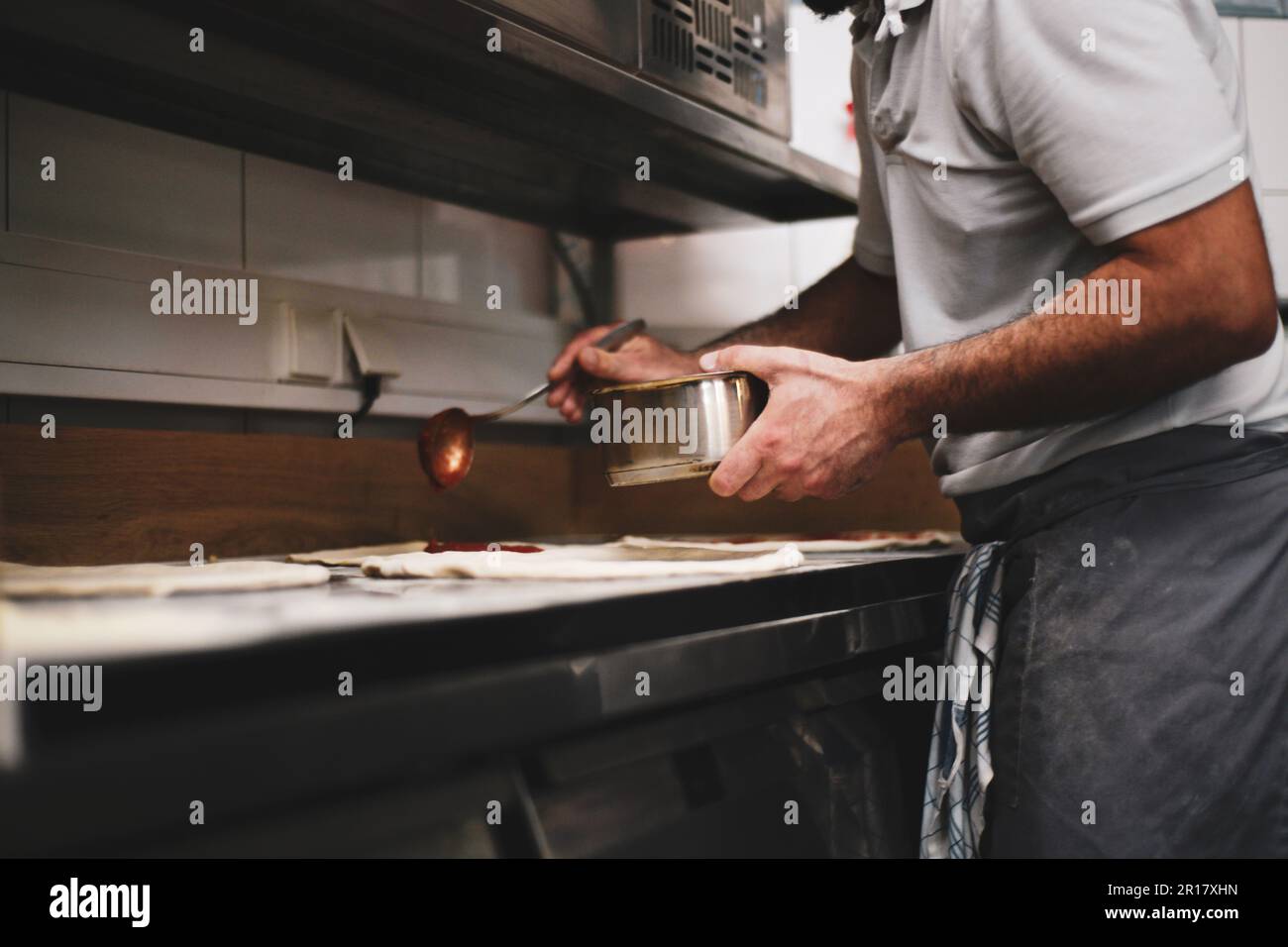 il pizzaiolo prepara l'impasto in una cucina a legna in germania Foto Stock