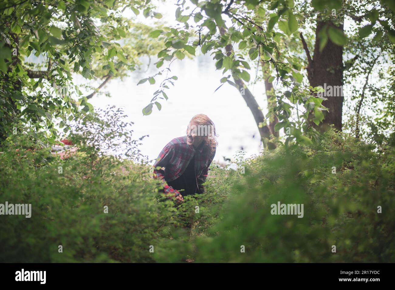 donna ride e danze come lei corre attraverso verde lussureggiante foresta Foto Stock