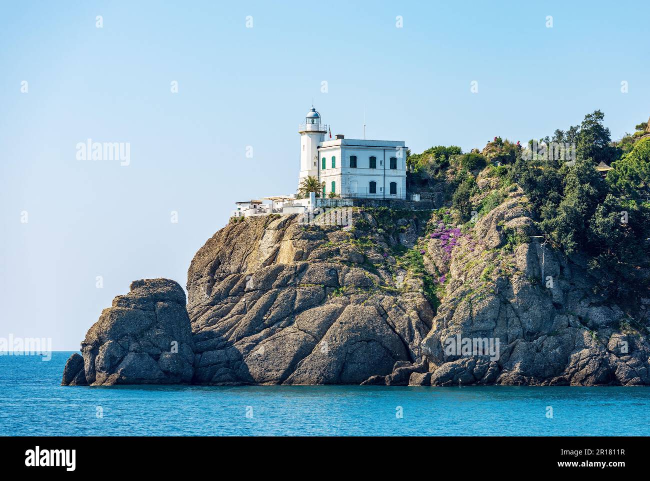 Costa del Mar Mediterraneo (Mar Ligure) con vecchio faro bianco. Porto di Portofino, provincia di Genova, Liguria, Italia, Europa. Foto Stock