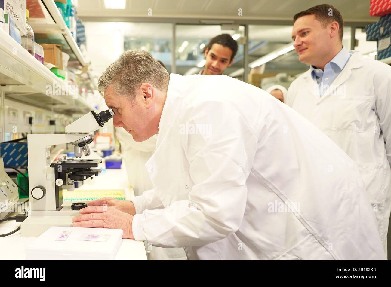 Leader del partito laburista Sir Keir Starmer guarda un tumore al polmone sotto un microscopio, con il segretario alla salute ombra Wes Streeting (a destra), durante una visita al Crick Institute, un istituto di ricerca biomedica, a Londra. Data immagine: Venerdì 12 maggio 2023. Foto Stock