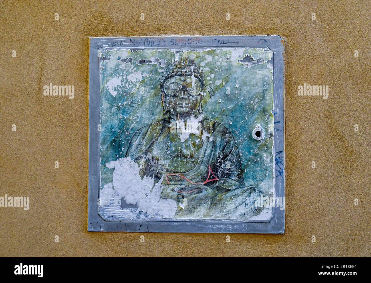 Misuratore di gas con un'opera d'arte sbiadita dell'artista di strada Blub raffigurante Buddha indossato una maschera subacquea, Venezia, Veneto, Italia Foto Stock