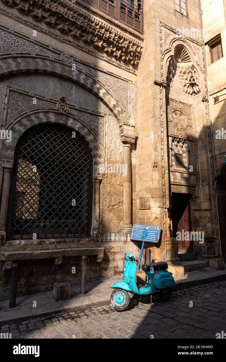 Cairo, Egitto. 21st Dec, 2022. Uno scooter a motore Vespa visto parcheggiato fuori Sabil-Kuttab di Katkhuda, in al Muizz Street vicino Khan El Khalili Bazaar nella parte vecchia del Cairo islamico, Egitto. Il Cairo, l'estesa capitale egiziana situata sulle rive del fiume Nilo, conosciuta in arabo come al Qahirah, che significa 'il vittorioso' è una megacità in continua espansione con una popolazione di oltre 20 milioni di persone. (Credit Image: © John Wreford/SOPA Images via ZUMA Press Wire) SOLO PER USO EDITORIALE! Non per USO commerciale! Foto Stock