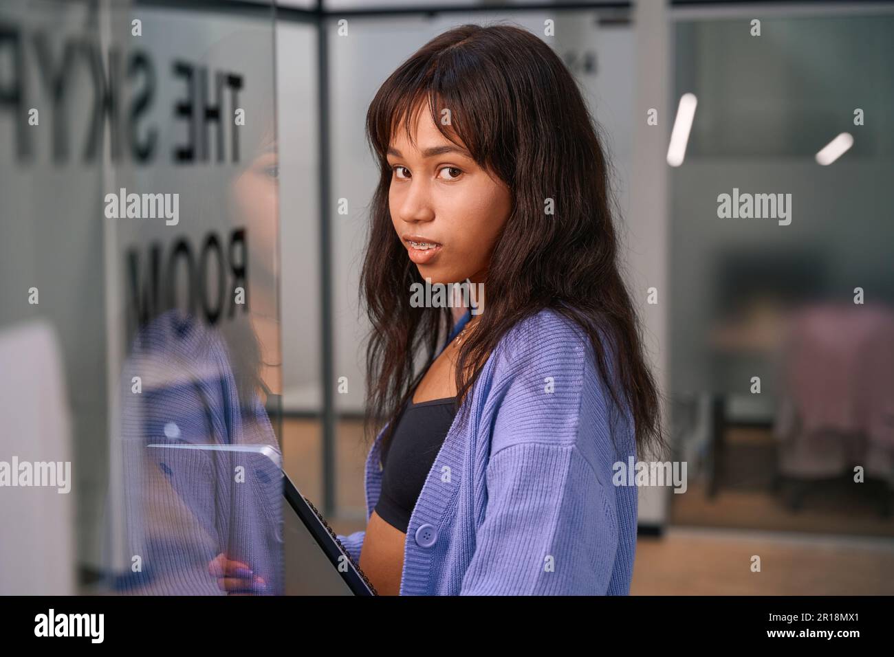 Bella lavoratrice in piedi all'ingresso della camera Foto Stock
