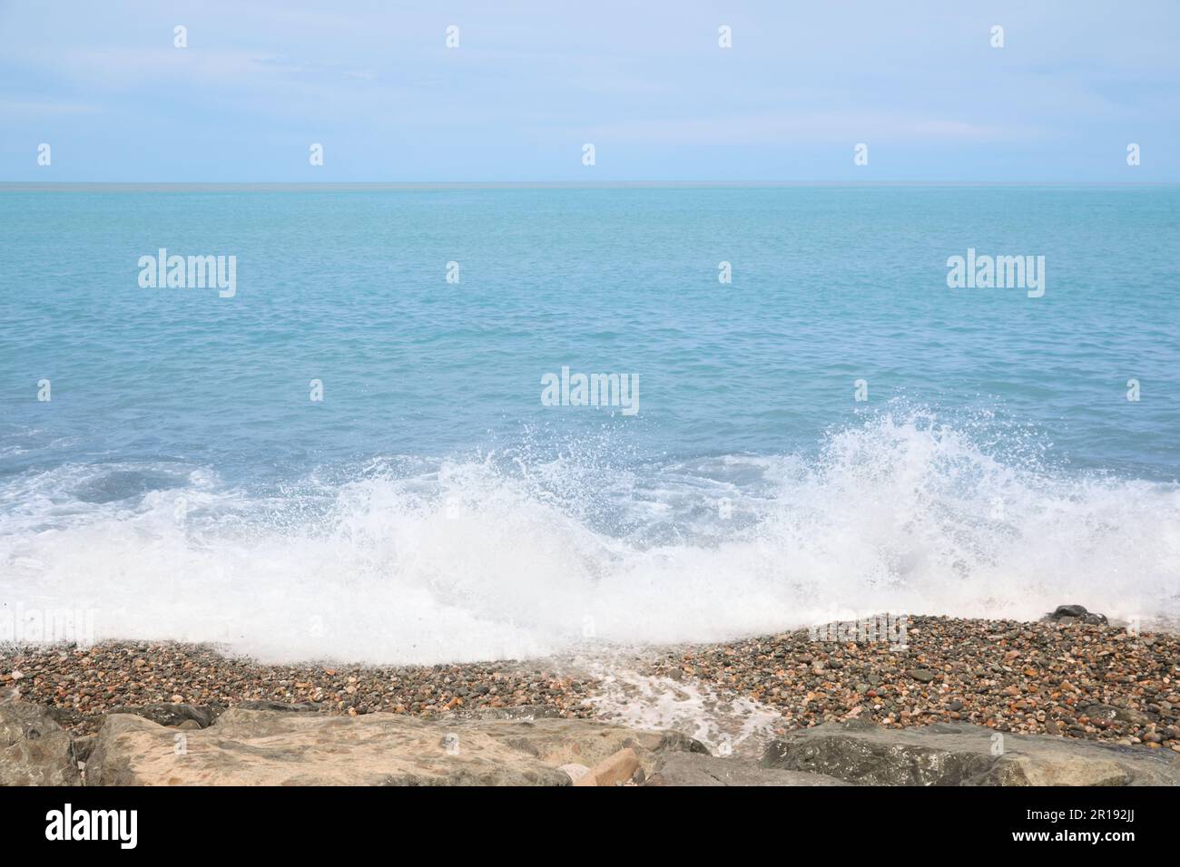 Pittoresca vista delle onde schiumose che colpiscono la costa rocciosa Foto Stock