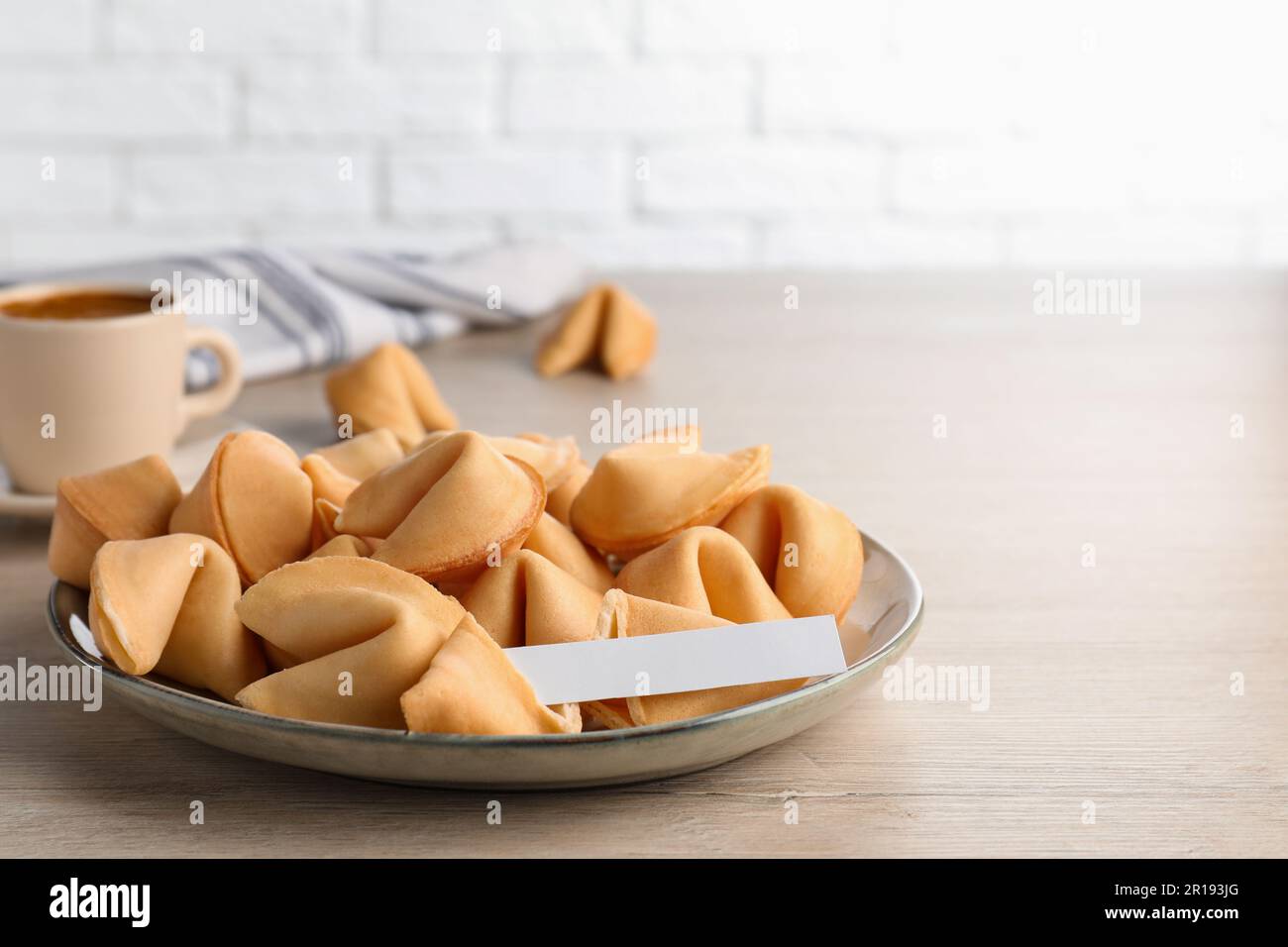 Gustosi biscotti e carta fortuna con predizione su tavolo di legno, spazio per il testo Foto Stock