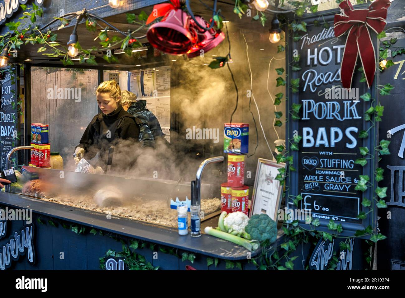 Street food mercato Regno Unito con venditore di braciole di maiale arrosto. Stratford Upon Avon, Warwickshire, Inghilterra, Regno Unito Foto Stock