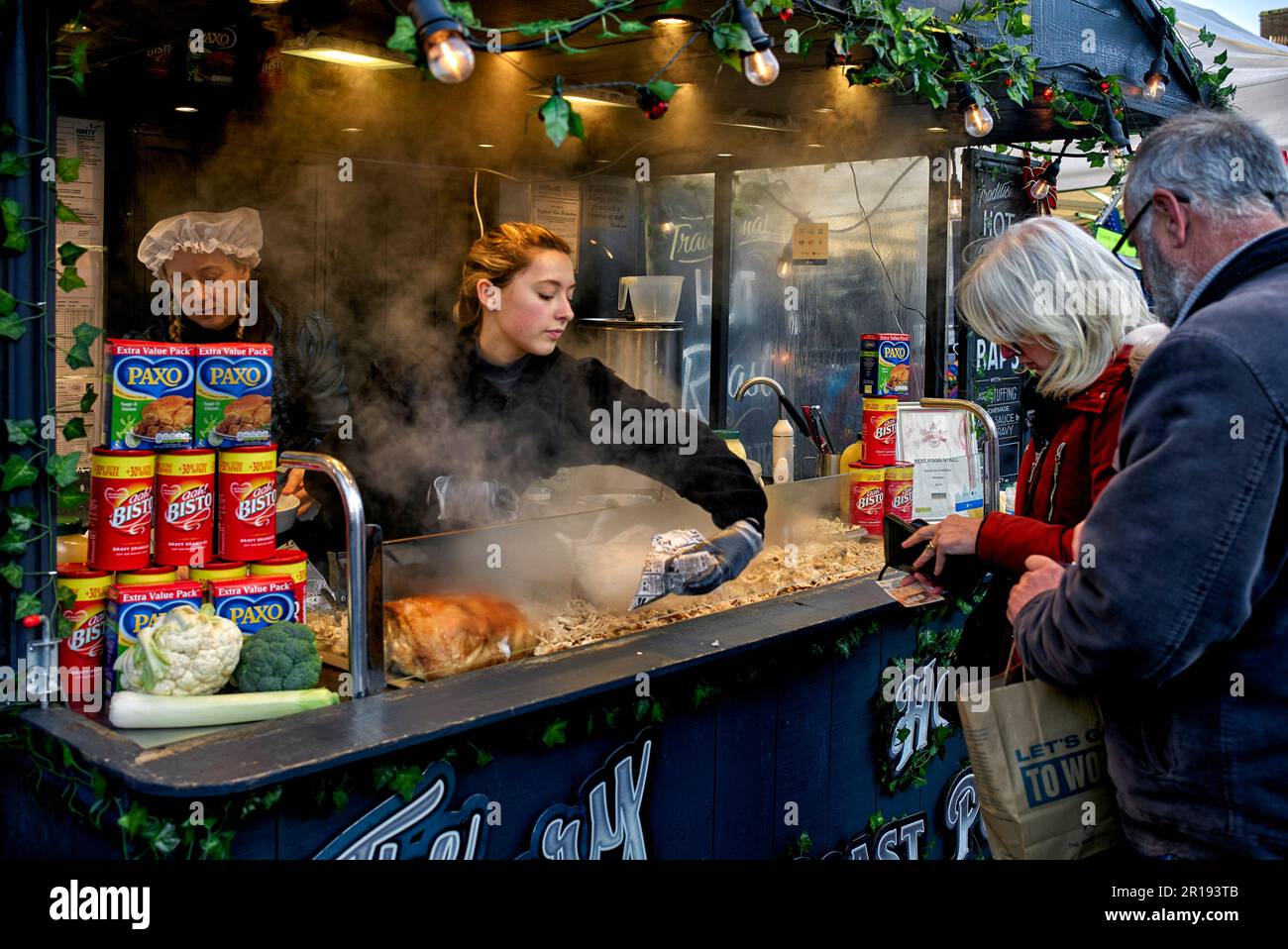Street food mercato Regno Unito con venditore di braciole di maiale arrosto. Stratford Upon Avon, Warwickshire, Inghilterra, Regno Unito Foto Stock