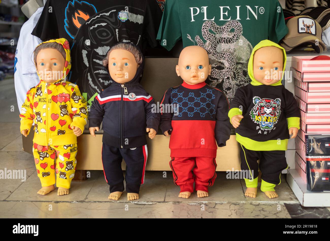Negozio per bambini manichini modello di abbigliamento fasullo designer in un negozio nel mercato di Alanya nella provincia di Antalya, Turchia. I marchi presentati includono Moschino, Plein Foto Stock