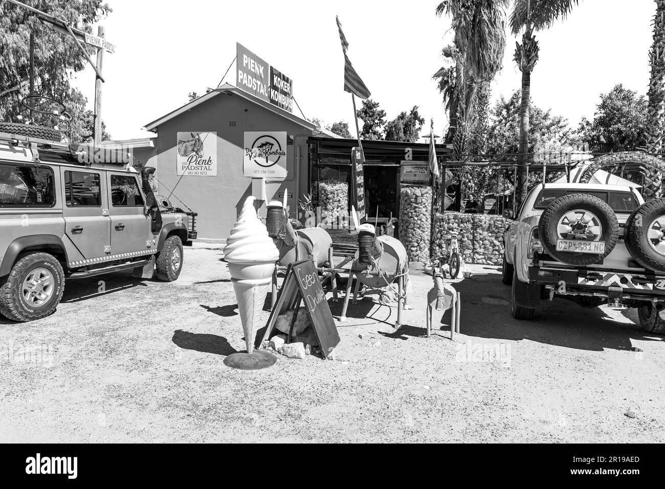 Kakamas, Sudafrica - 25 febbraio 2023: Il Pienk Padstal e Koker Kombuis a Kakamas nella Provincia del Capo Settentrionale. I veicoli sono visibili. Monocromatico Foto Stock