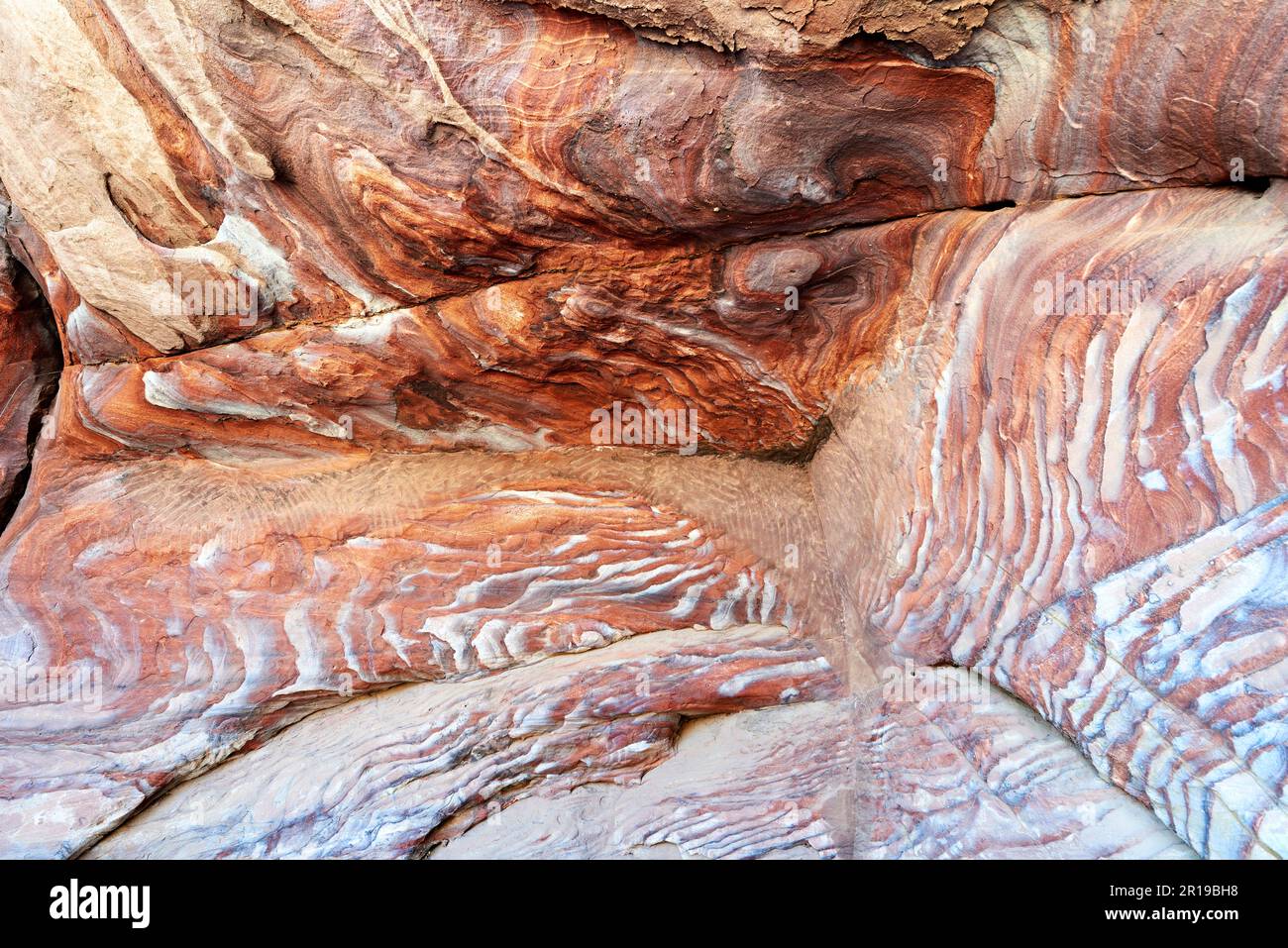 Giordania. Sito archeologico di Petra. Rocce rosse colorate nella grotta Foto Stock