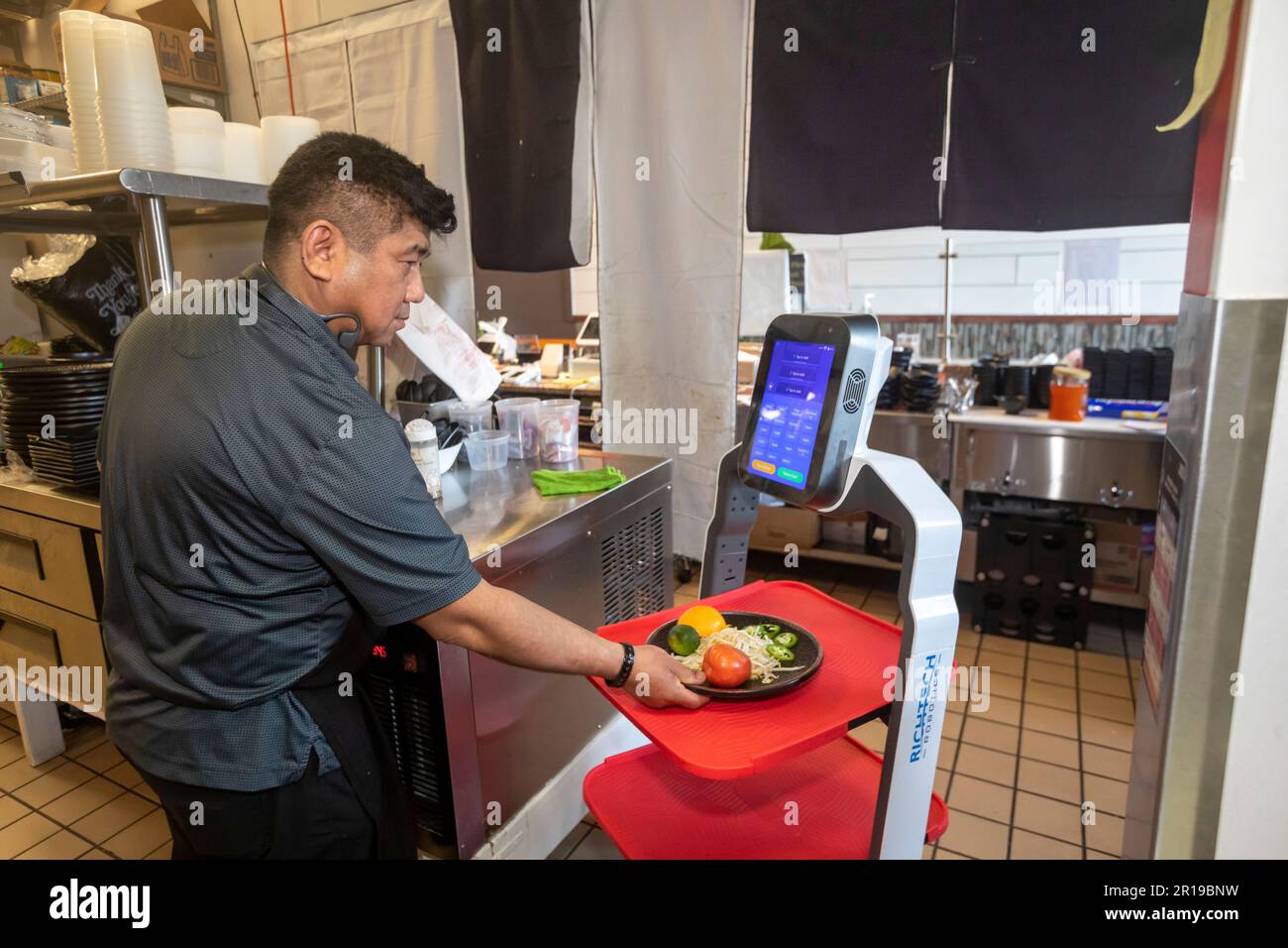 Troy, Michigan - Un robot Matradee della Richtec Robotics consegna il cibo ai commensali al Pho-Shi, un ristorante fusion asiatico. In cucina, ristorante proprietario va Foto Stock