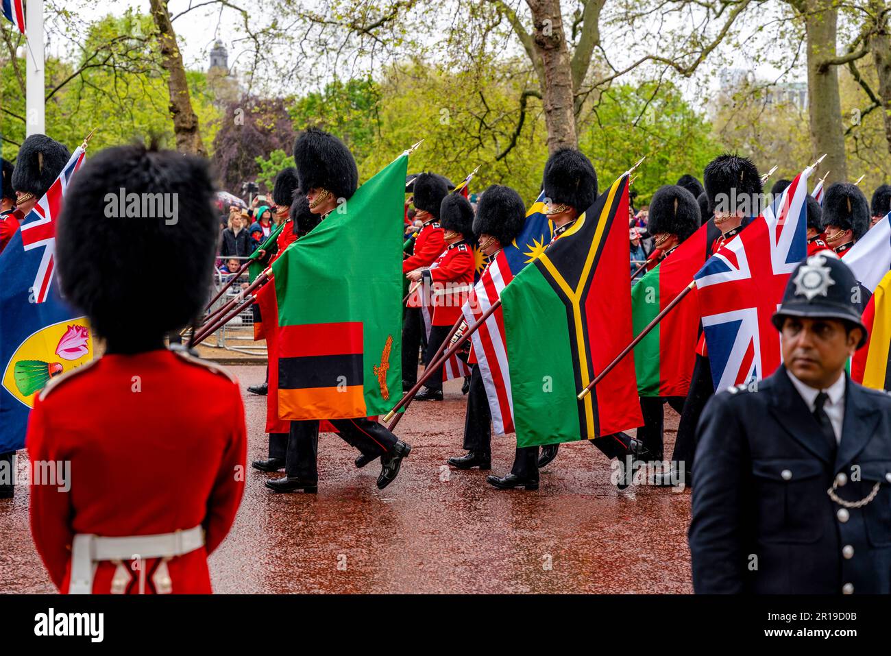 I soldati britannici trasportano le bandiere dei paesi del Commonwealth come parte della processione del re, dell'incoronazione del re Carlo III, del centro commerciale, Londra, Regno Unito Foto Stock