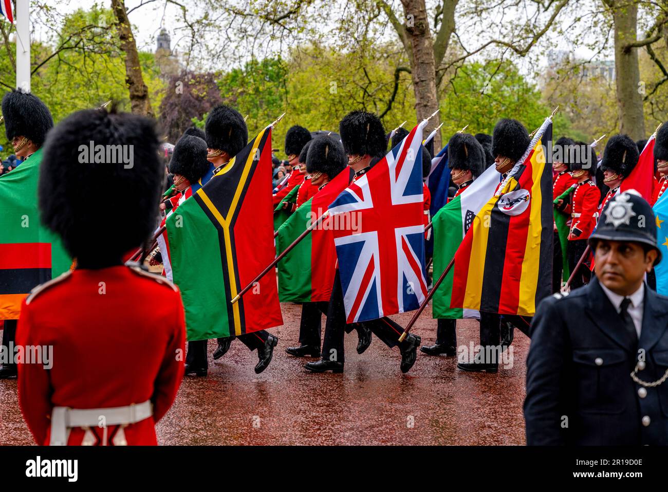 I soldati britannici trasportano le bandiere dei paesi del Commonwealth come parte della processione del re, dell'incoronazione del re Carlo III, del centro commerciale, Londra, Regno Unito Foto Stock