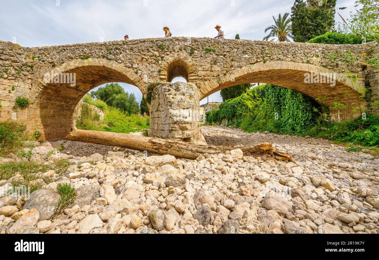 Persone che attraversano Pont Roma il ponte romano sul torrente stagionalmente secco di Sant Jordi attraverso Pollenca nei Monti Tramuntana di Maiorca Spagna Foto Stock