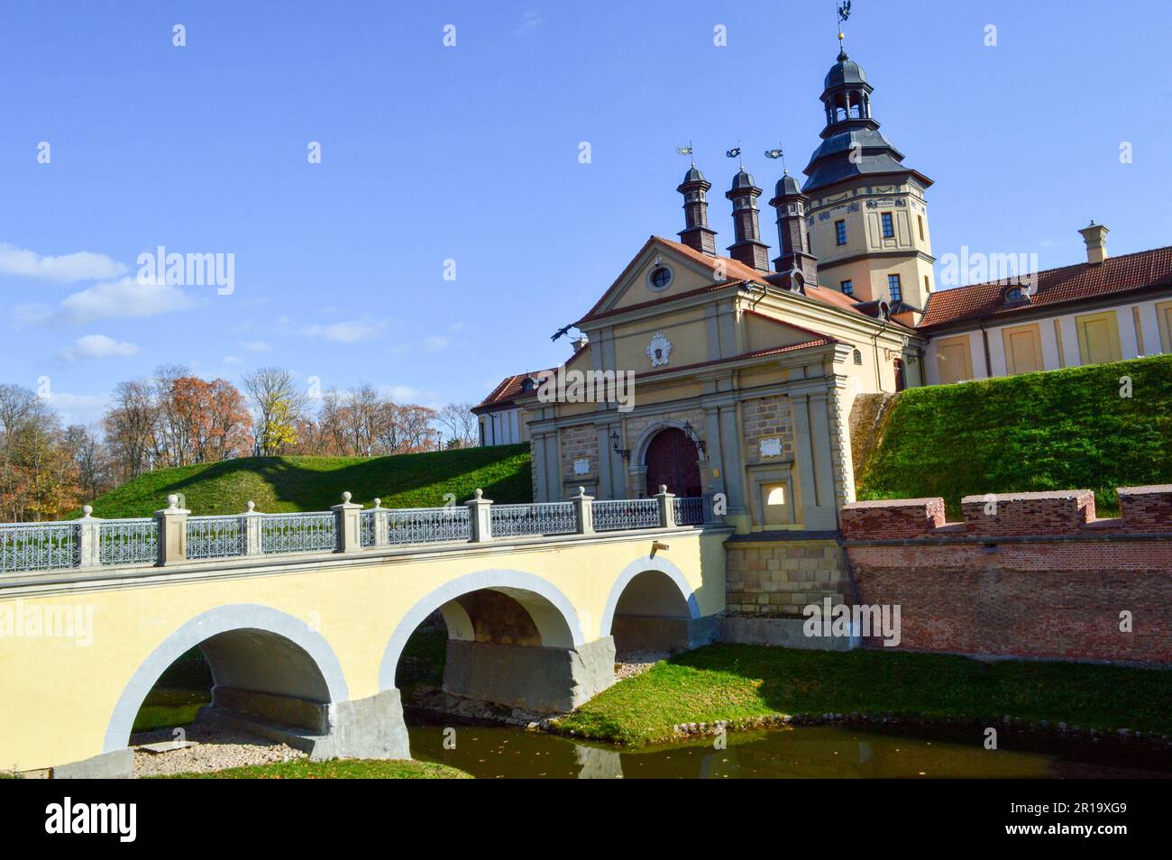 Antico castello medioevale con guglie e torri, mura di pietra e mattoni circondate da un fossato protettivo con acqua nel centro d'Europa. BARO Foto Stock
