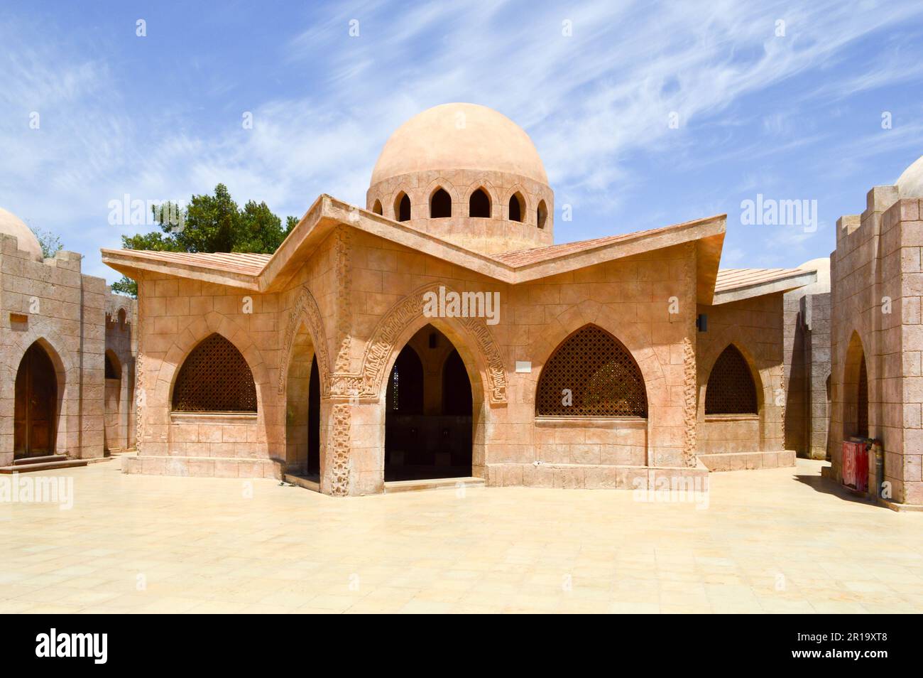 Piccole belle case arabe musulmane in pietra pulite con cupole rotonde nel deserto con palme in un paese tropicale. Foto Stock