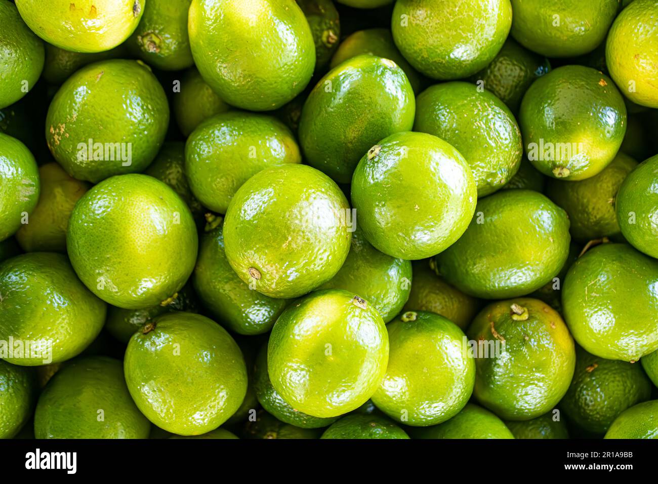 Diversi bellissimi limoni verdi su un terreno fieristico in legno. Foto Stock