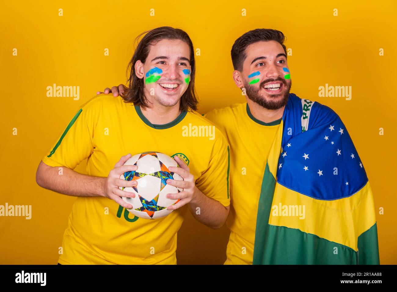 Amici brasiliani, latinoamericani, la diversità, il tifo per il brasile, nella Coppa del mondo 2022, tenendo la palla e la bandiera, attento al gioco, felice Foto Stock