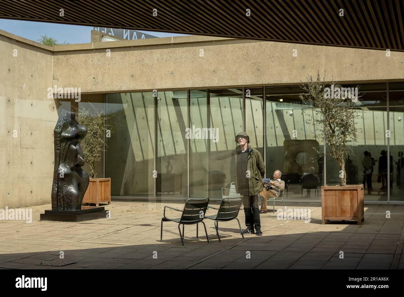 Piazza patio di architettura contemporanea in un moderno museo di sculture con persone su una terrazza di statue, spazio esterno interno altamente stilizzato Foto Stock