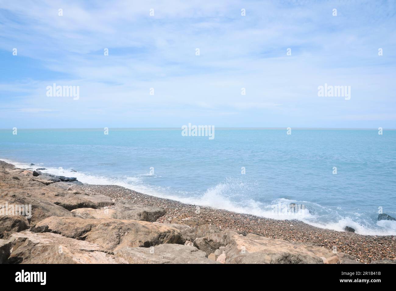 Pittoresca vista delle onde schiumose che colpiscono la costa rocciosa Foto Stock