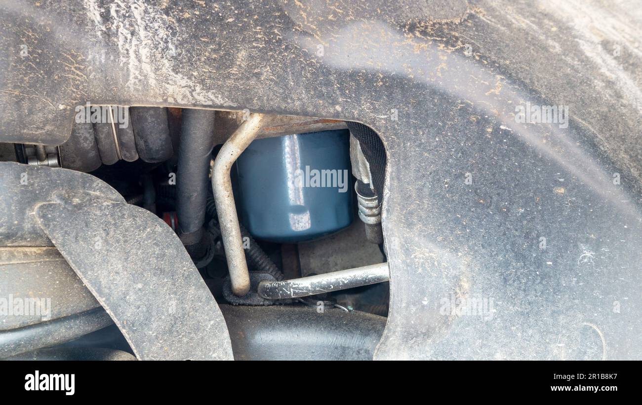 Osservare un filtro dell'olio attraverso l'apertura della ruota Foto Stock Osservare un filtro dell'olio attraverso l'apertura della ruota Foto Stock