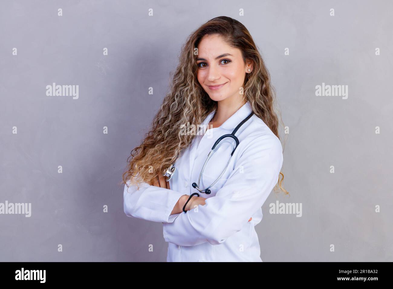 Ritratto di sicuro con il sorriso toothy beaming qualificato esperto intelligente medico indossando bianco formale indossa che è in piedi con incrociati Foto Stock