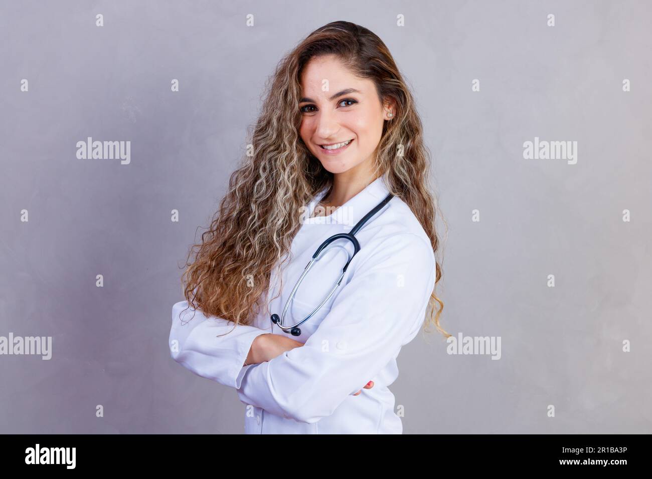 Ritratto di sicuro con il sorriso toothy beaming qualificato esperto intelligente medico indossando bianco formale indossa che è in piedi con incrociati Foto Stock