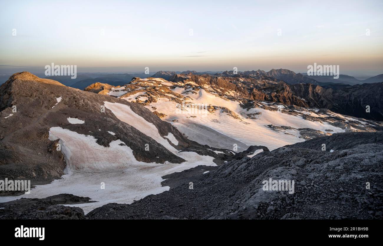 Vista dell'altopiano roccioso con neve e ghiacciaio all'alba, sul monte Hochkoenig, l'Alpe di Uebergossene, vista sulle Steinernes Meer e Watchmann, Berchtesgaden Foto Stock