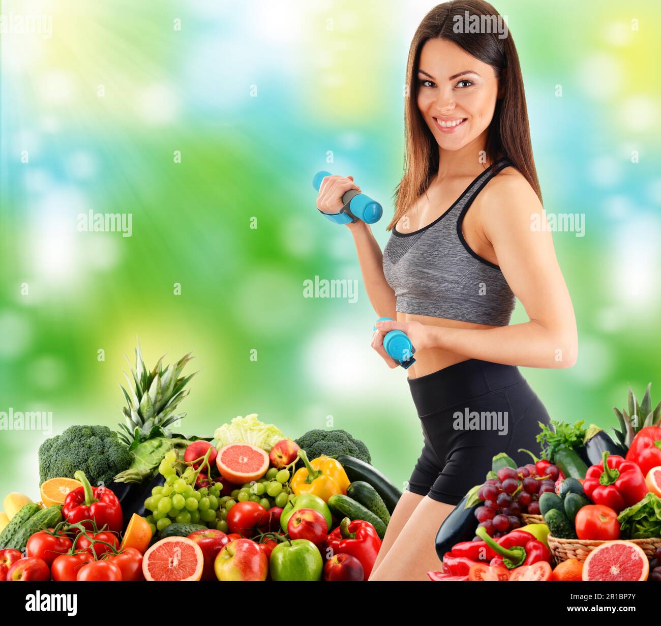 Giovane donna con varietà di verdure e frutta biologiche. Dieta equilibrata Foto Stock