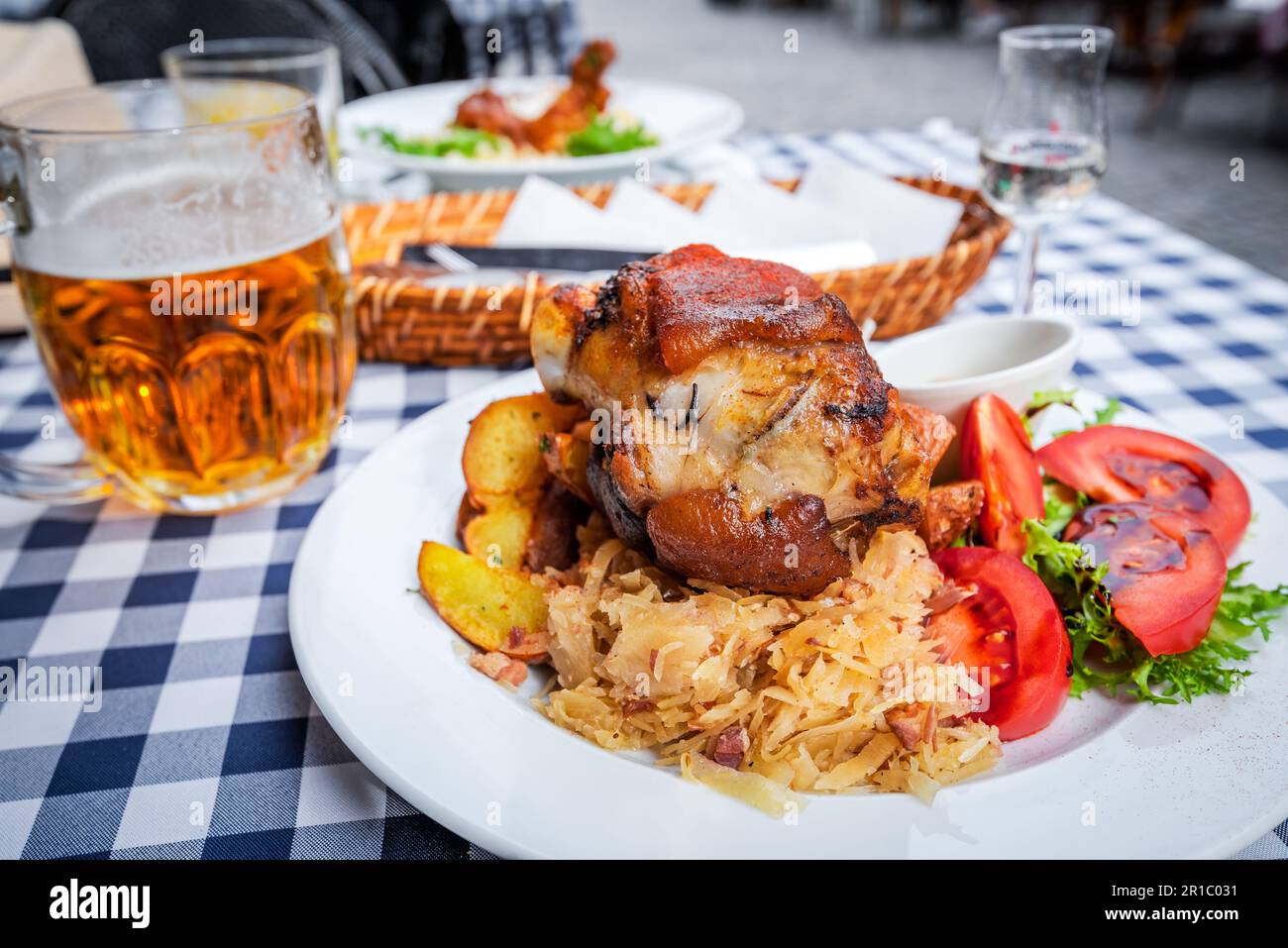 Zeppa di maiale al forno con birra, cavolo bavarese e aglio, patate al prezzemolo bistecca, Schweinshaxe. Foto Stock