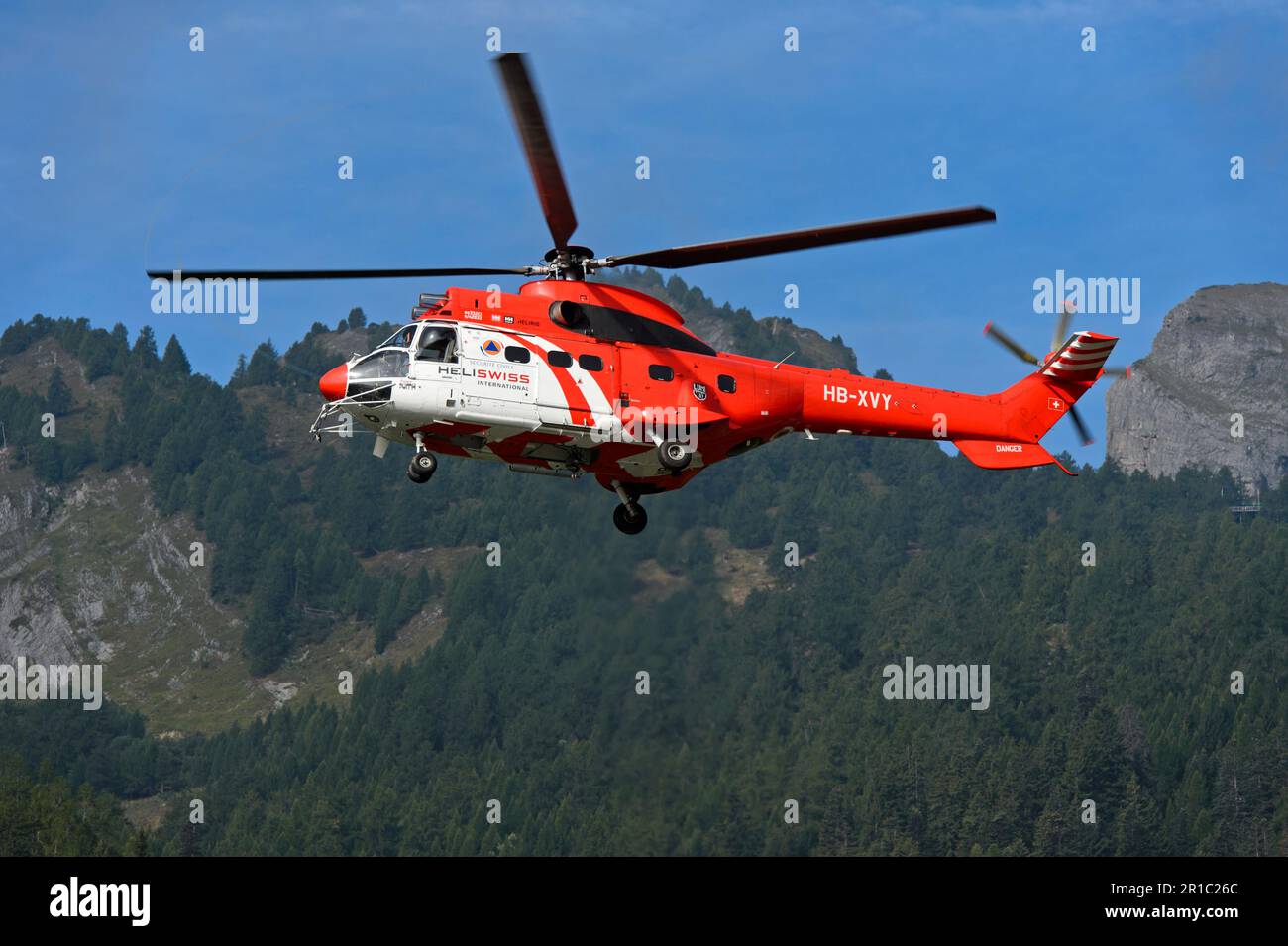 Elicottero da trasporto multiuso AS 332 Super Puma C1 HB-XVY di Heliswiss International AG in volo nel cantone del Vallese, Svizzera Foto Stock